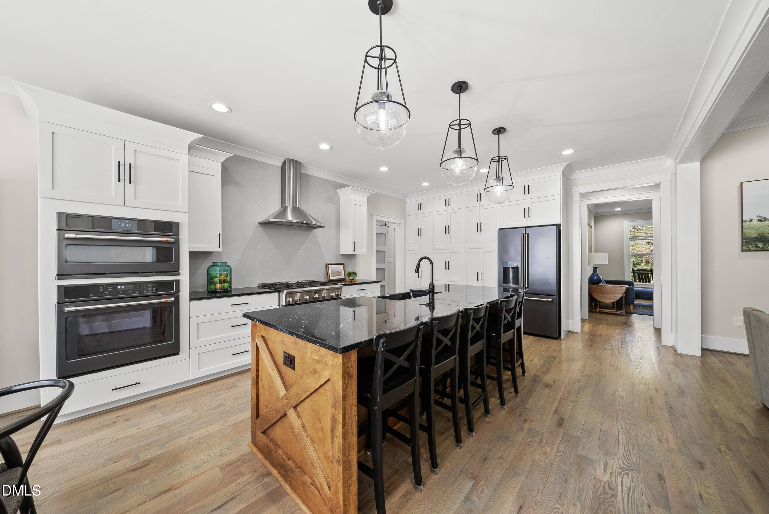 2416 Eddie Howard Road Willow Spring, NC 27592 - Photo 42 of 64 a kitchen with stainless steel appliances a dining table chairs and wooden floor