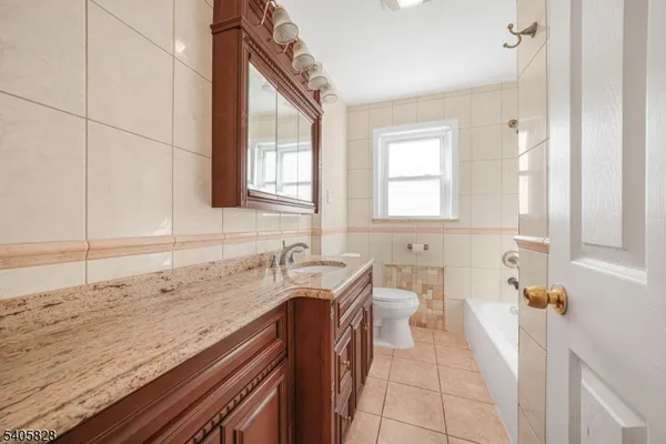 a bathroom with a granite countertop sink a mirror and a bathtub