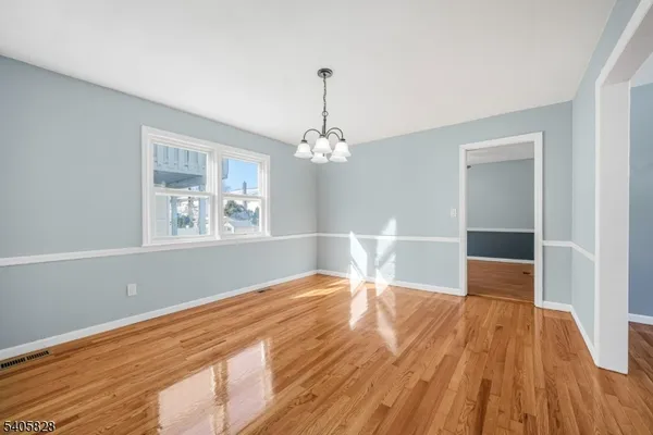 a view of a room with wooden floor staircase and a chandelier
