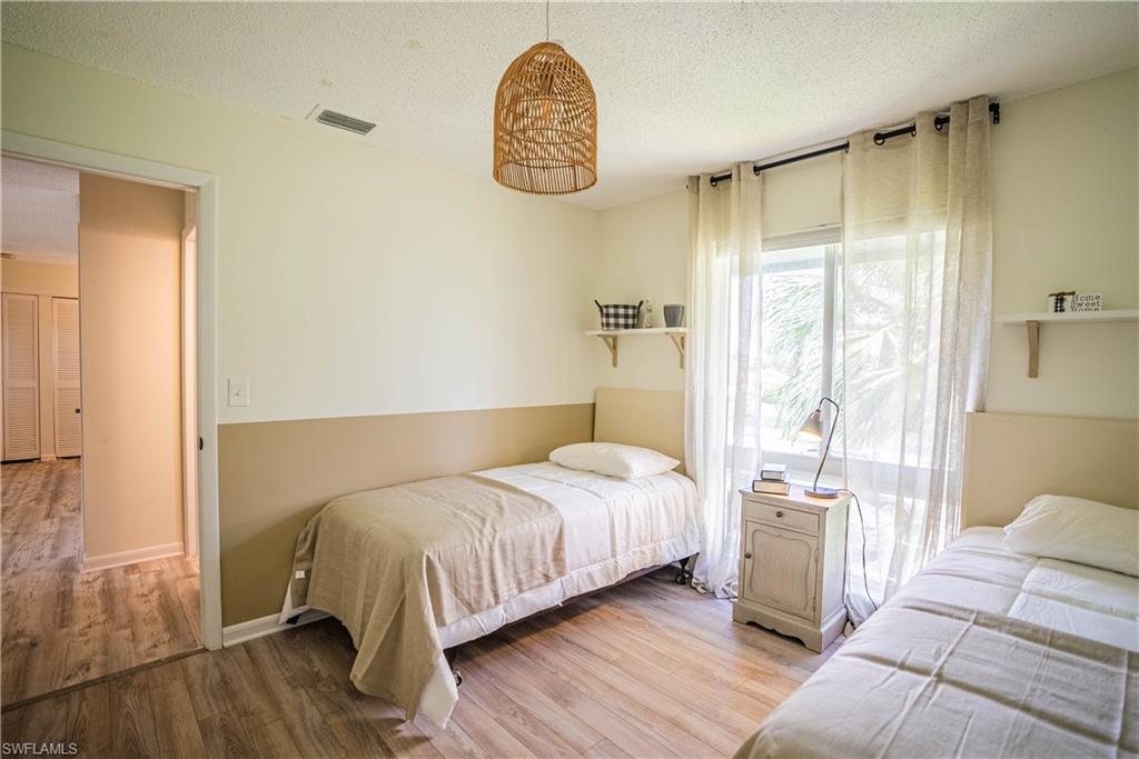 162 Teryl Road, Unit 4 Naples, FL 34112 - Photo 18 of 20 a bedroom with a bed a mirror and a window