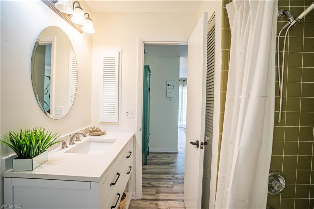 162 Teryl Road, Unit 4 Naples, FL 34112 - Photo 19 of 20 a bathroom with a sink a mirror a potted plant and a mirror