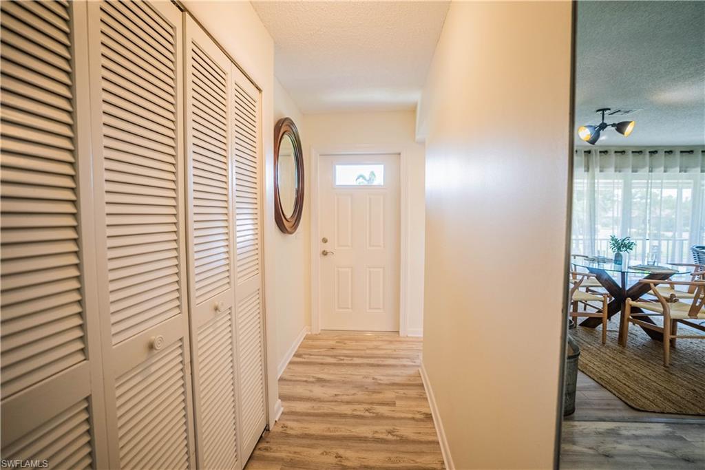 162 Teryl Road, Unit 4 Naples, FL 34112 - Photo 6 of 20 a view of a hallway with wooden floor and dining room view