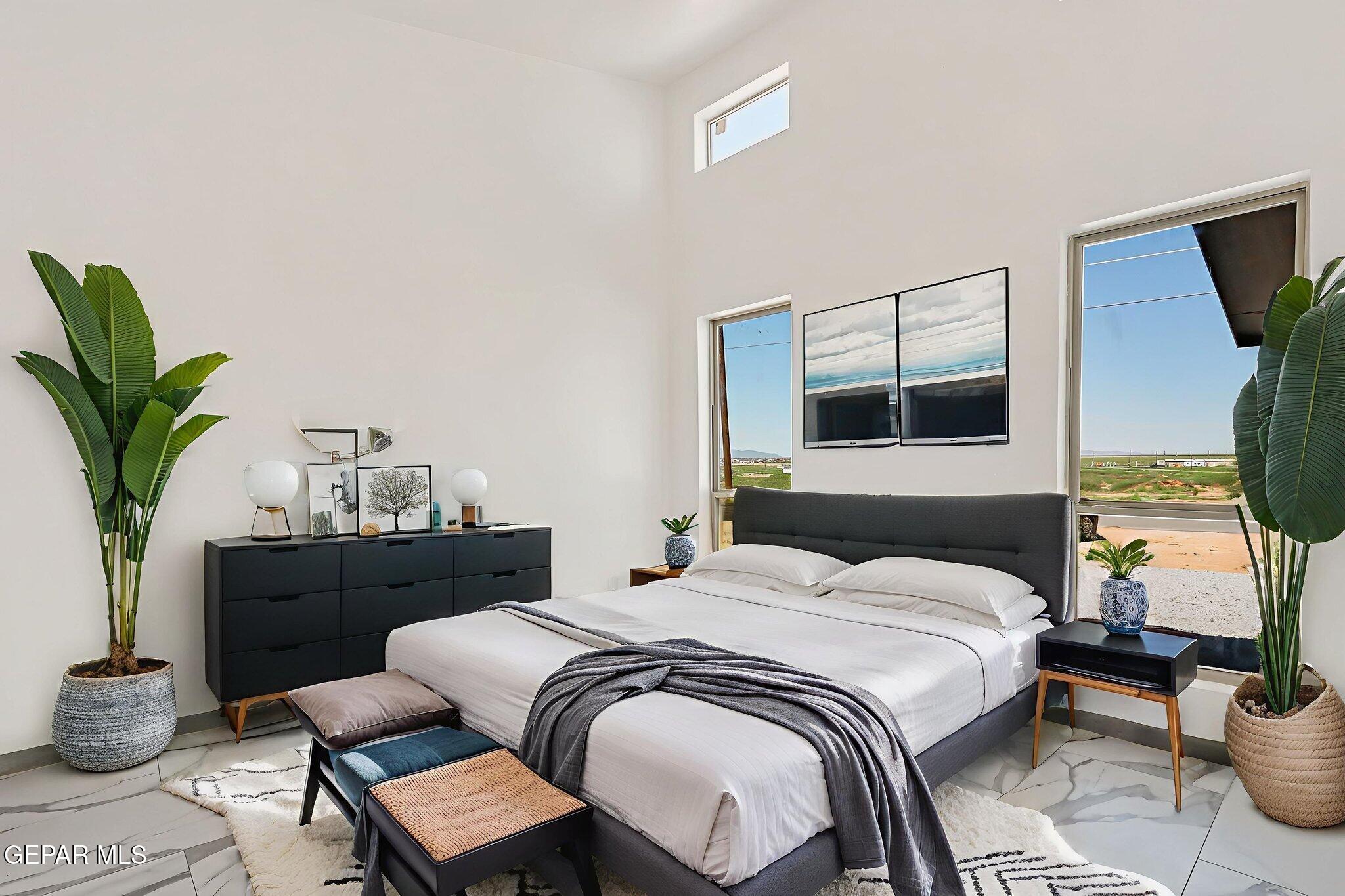 693 San Jose Chaparral, NM 88081 - Photo 22 of 40 a bedroom with a bed table flowerpot and window