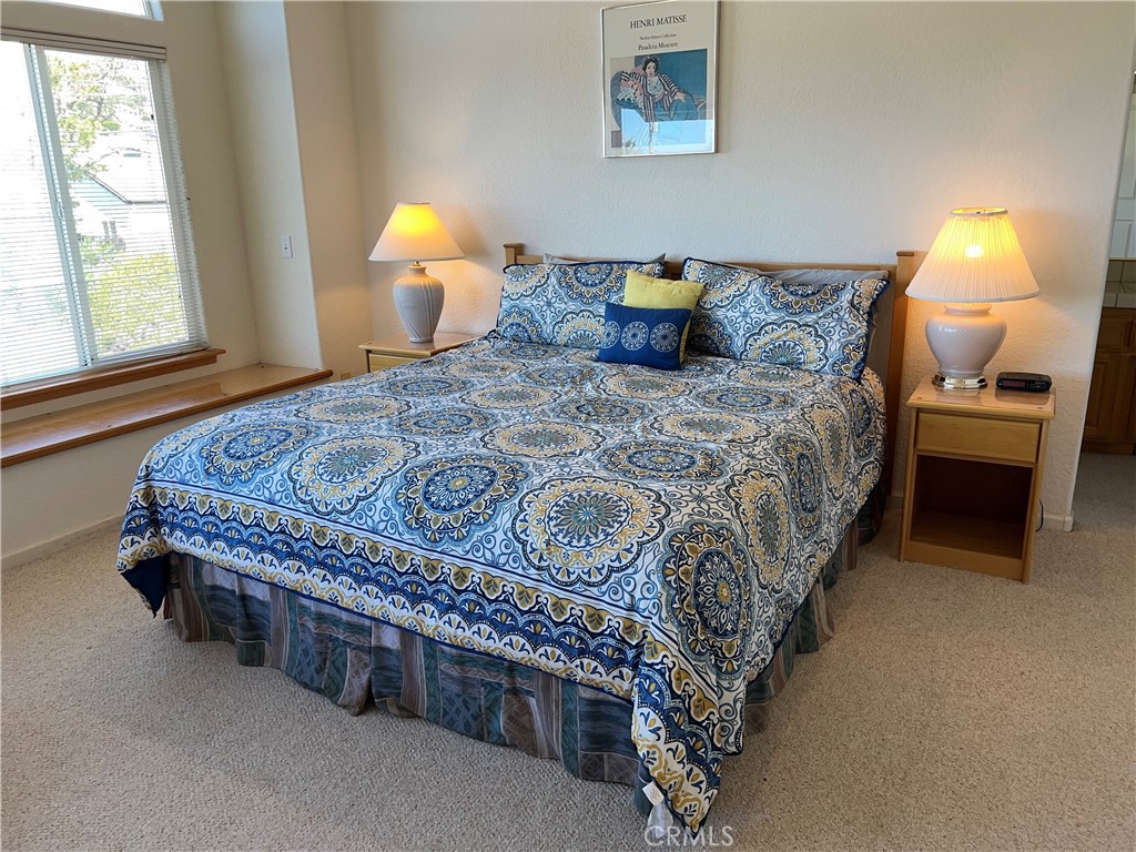 330 Jean Street Cambria, CA 93428 - Photo 29 of 75 a bedroom with a bed and a lamp next to a window