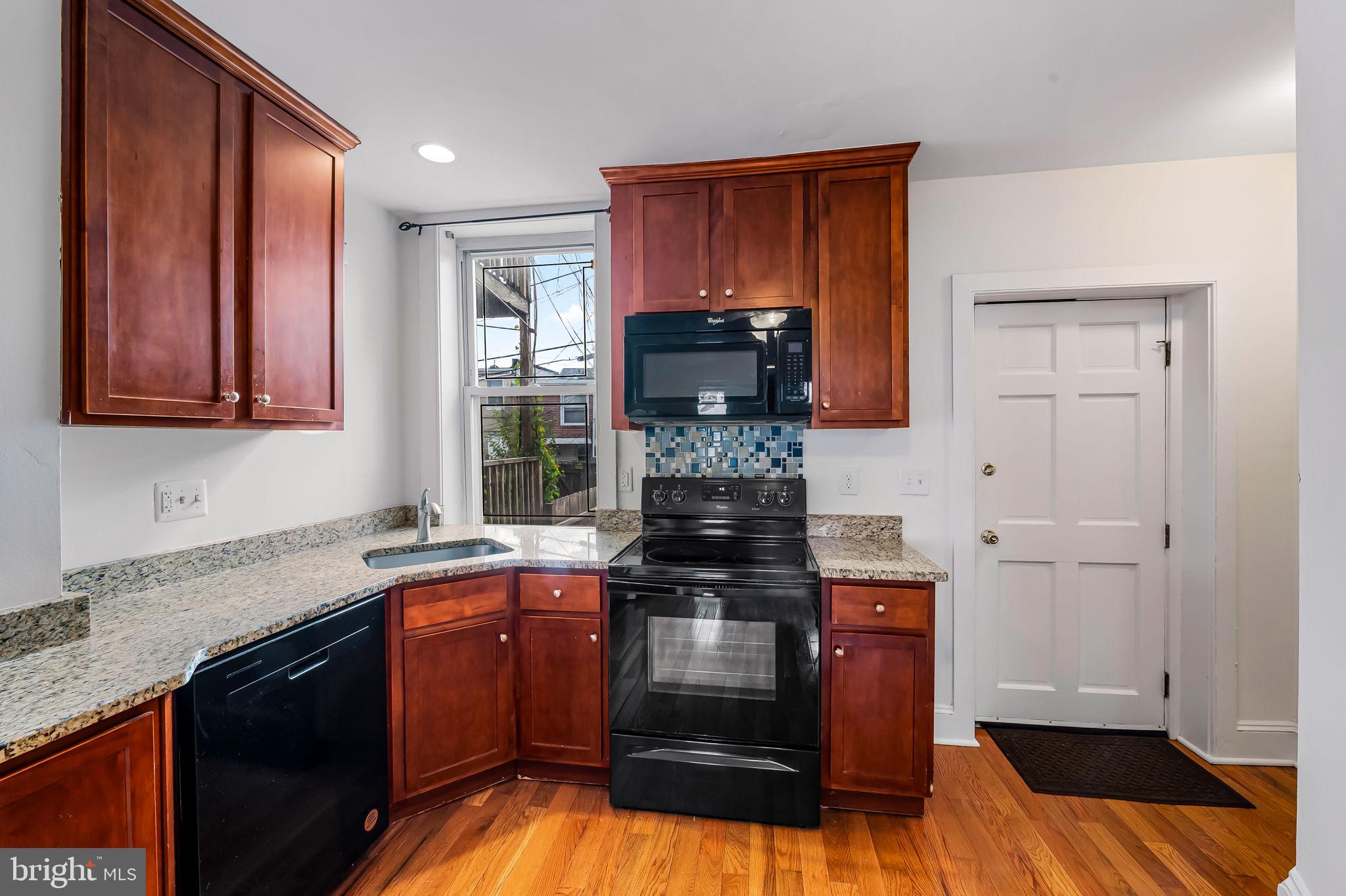 649 Portland Street Baltimore, MD 21230 - Photo 11 of 34 a kitchen with stainless steel appliances granite countertop a stove a sink and a microwave