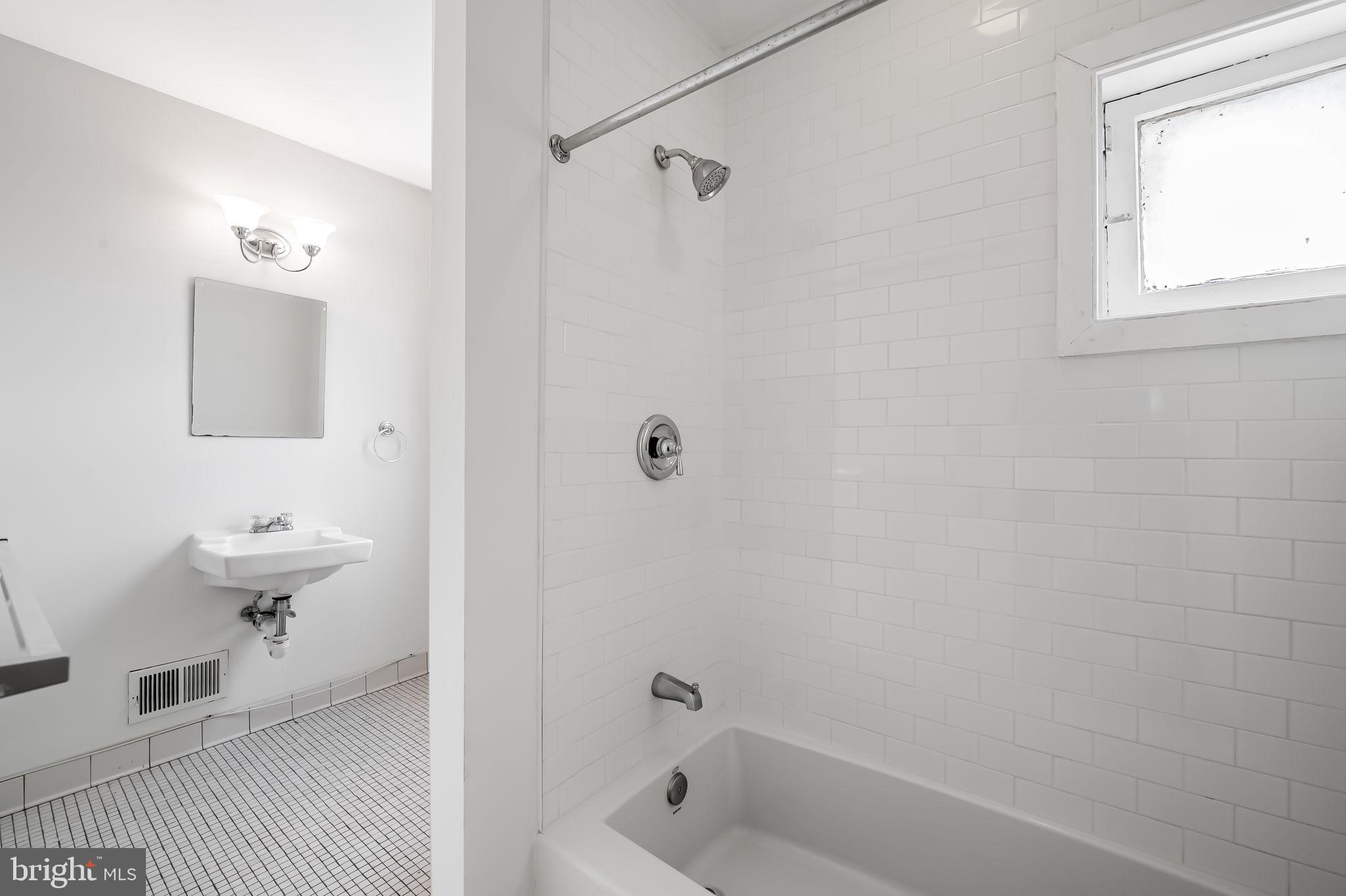 649 Portland Street Baltimore, MD 21230 - Photo 18 of 34 a bathroom with a bathtub a toilet and a shower