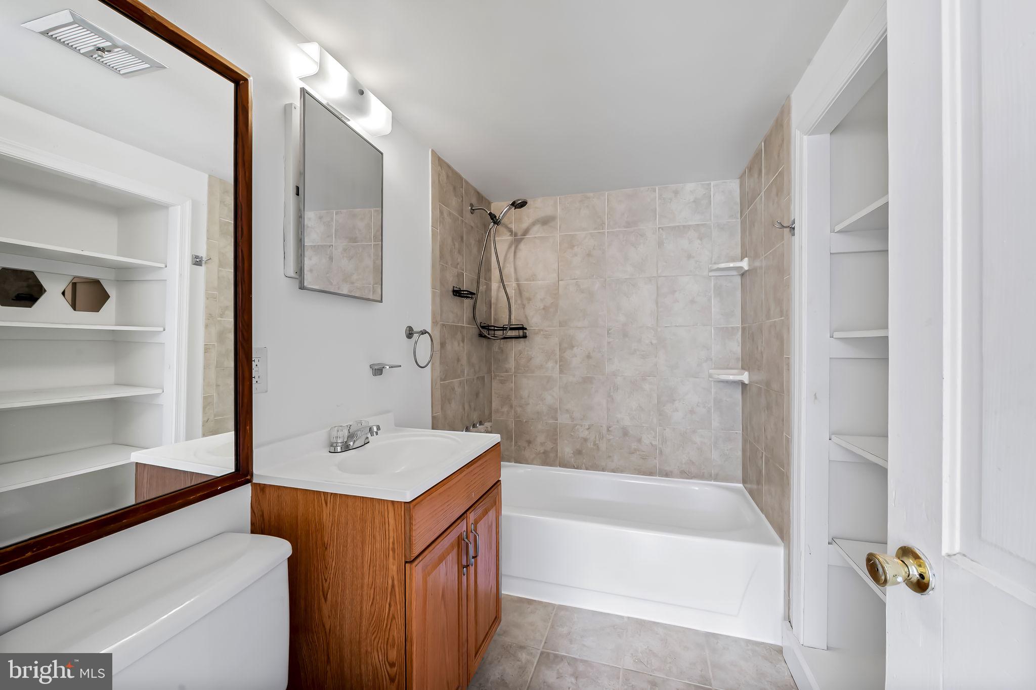 649 Portland Street Baltimore, MD 21230 - Photo 28 of 34 a bathroom with a tub sink shower and a mirror