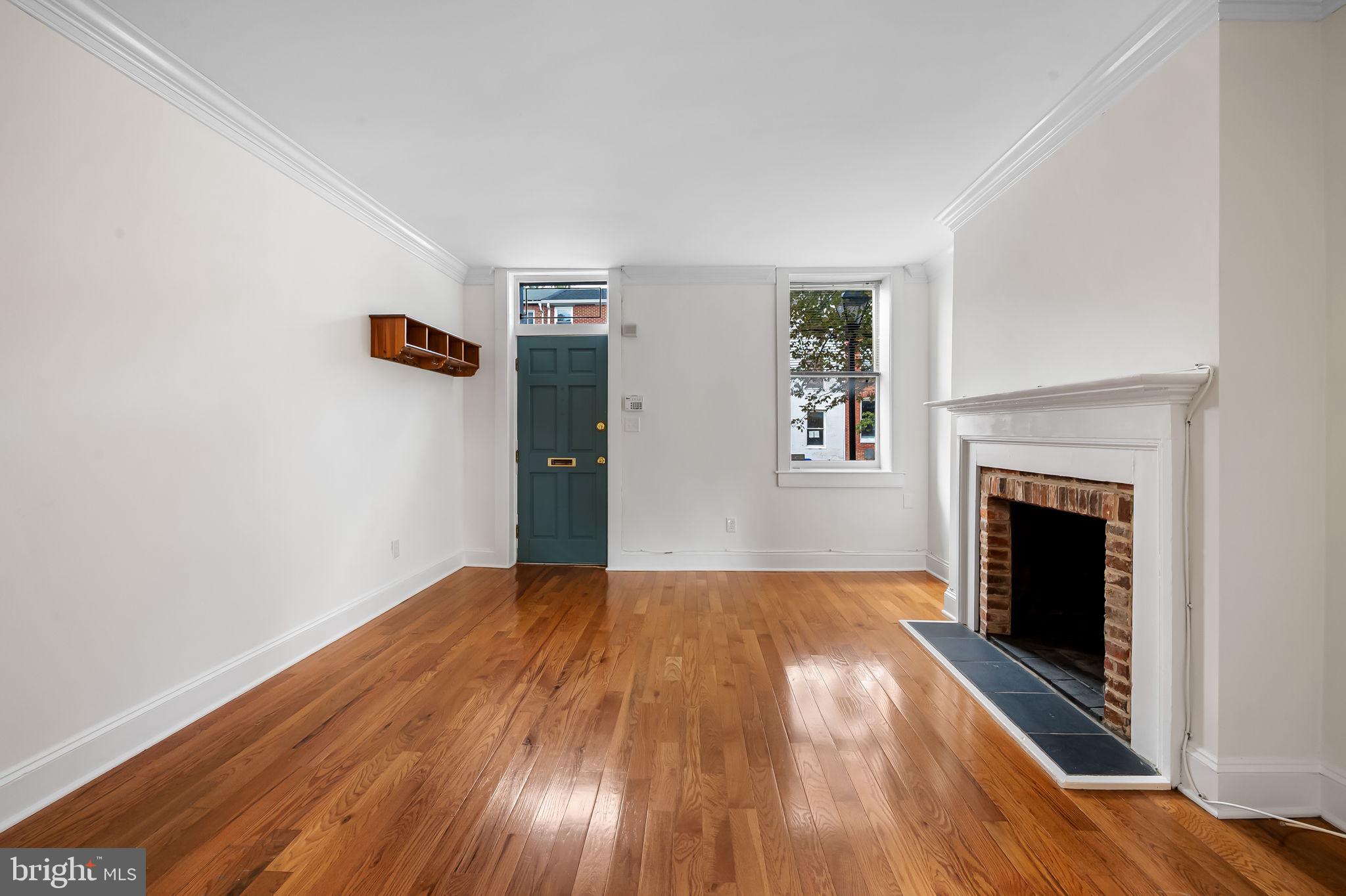 649 Portland Street Baltimore, MD 21230 - Photo 6 of 34 a view of empty room with wooden floor and fireplace