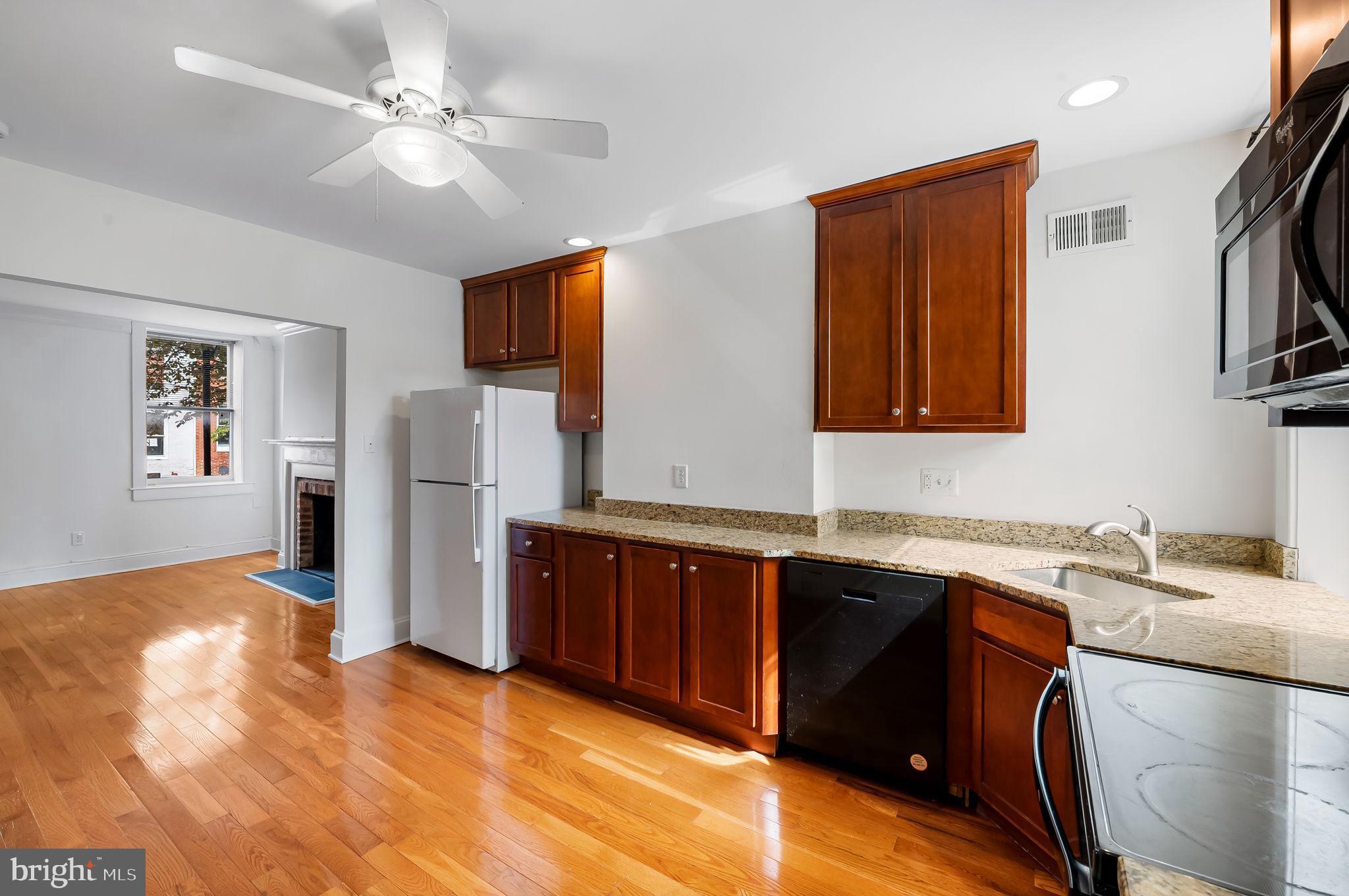 649 Portland Street Baltimore, MD 21230 - Photo 9 of 34 a kitchen with stainless steel appliances granite countertop a sink stove and refrigerator