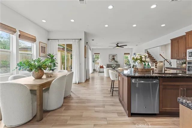 a kitchen with stainless steel appliances granite countertop a table chairs and wooden floor