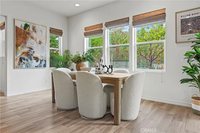 a dining room with wooden floor and a potted plant