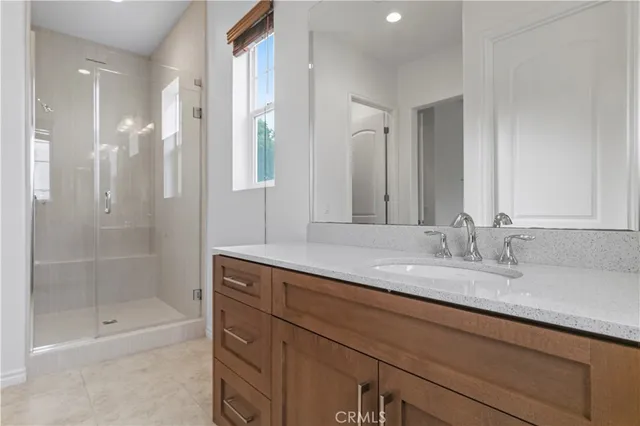 a bathroom with a granite countertop sink a mirror and a bathtub