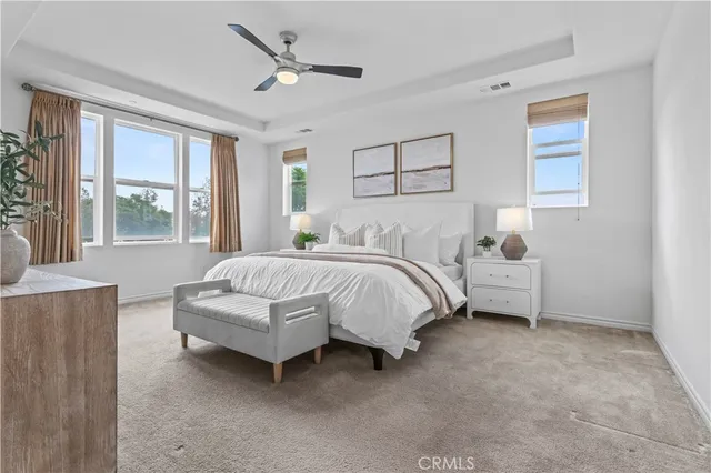 a spacious bedroom with a bed and a chandelier