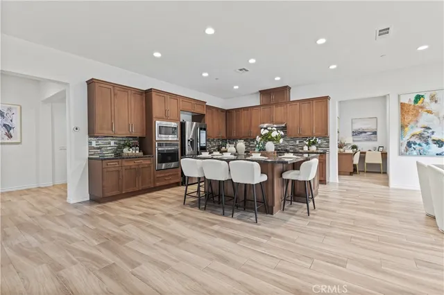 a kitchen with a dining table chairs and refrigerator