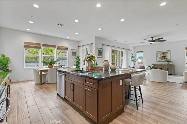 a kitchen with stainless steel appliances granite countertop a stove and a view of living room