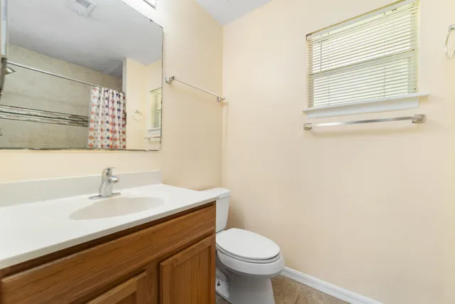 a bathroom with a sink toilet and a mirror