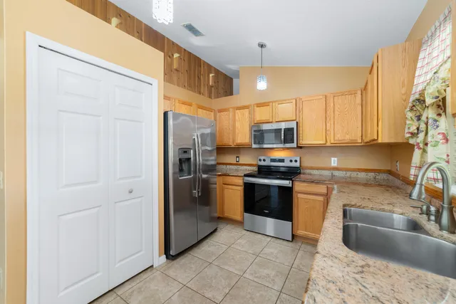 a kitchen with stainless steel appliances granite countertop a refrigerator and a sink