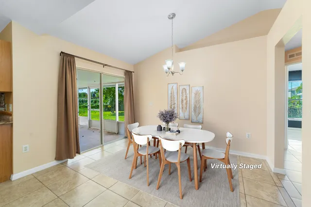 a view of a dining room and livingroom with furniture wooden floor a chandelier