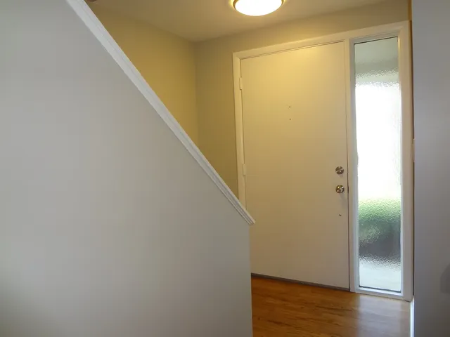 a view of a hallway with wooden floor and closet