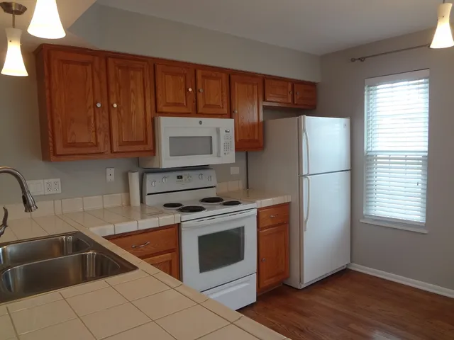 a kitchen with a refrigerator sink and cabinets