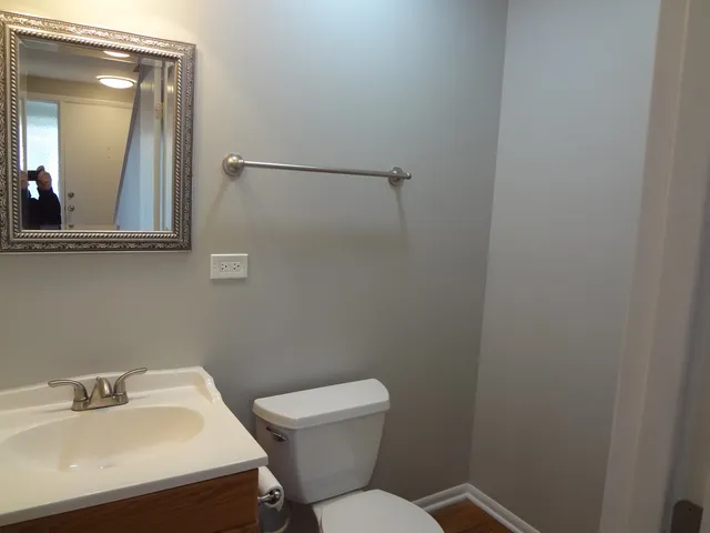 a bathroom with a sink mirror and toilet