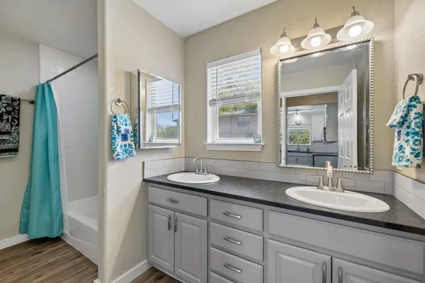 a bathroom with a granite countertop sink a mirror and a shower