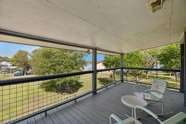 a view of a balcony with chairs and wooden floor