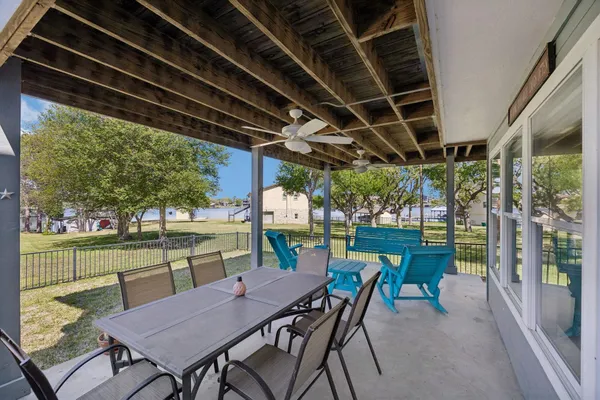 a view of a backyard with table and chairs potted plants with floor to ceiling window