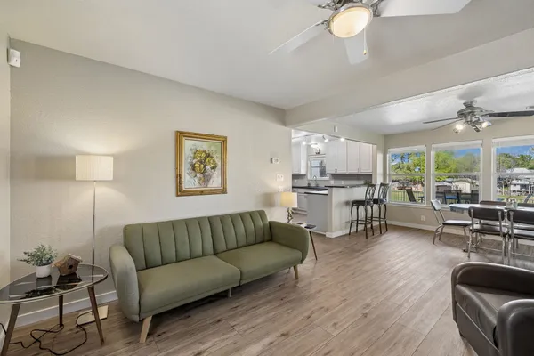 a living room with furniture kitchen view and a large window