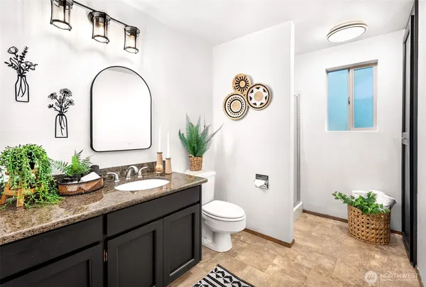 a spacious bathroom with a granite countertop sink a toilet and a mirror