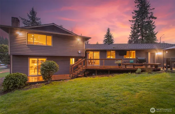 a view of a house with backyard and sitting area