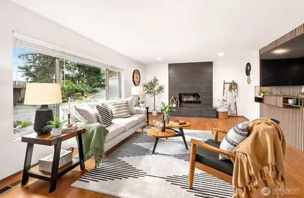 a living room with furniture a flat screen tv and a large window