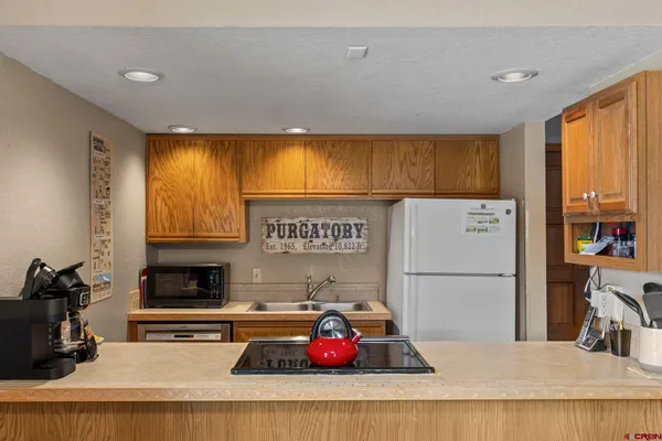 a kitchen with stainless steel appliances granite countertop a refrigerator sink stove and cabinets