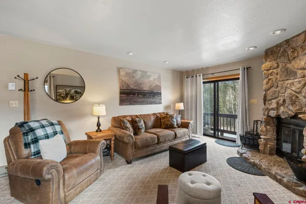 a living room with furniture a fireplace and a flat screen tv