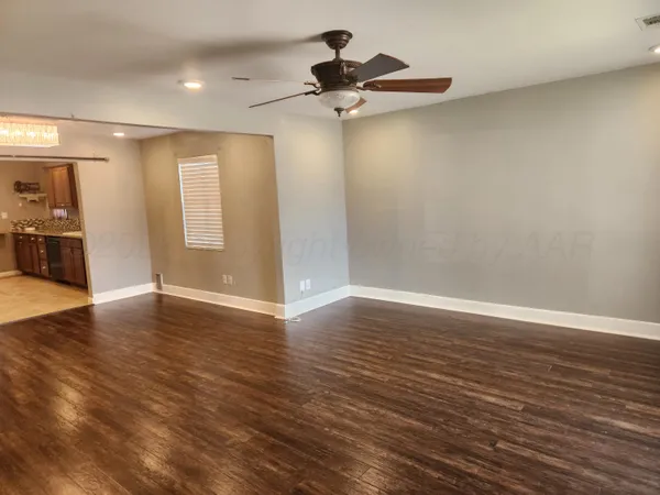 a view of a room with wooden floor and a ceiling fan