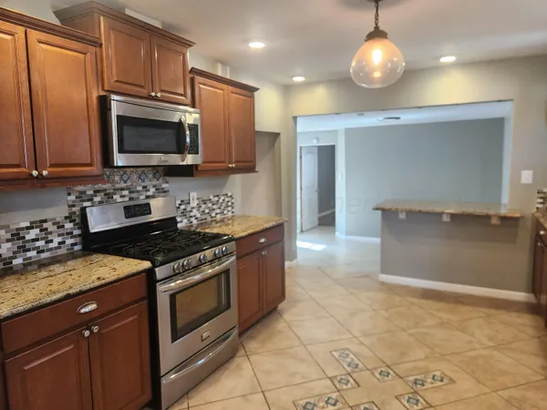 a kitchen with stainless steel appliances granite countertop a stove and a microwave