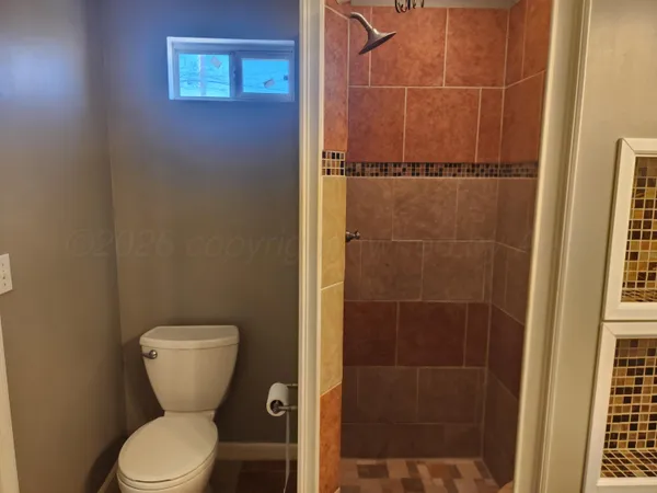 a bathroom with a toilet and a shower