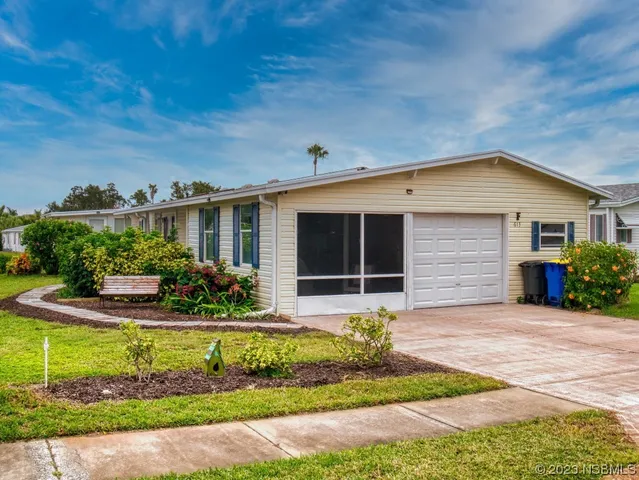 a front view of a house with a yard and potted plants