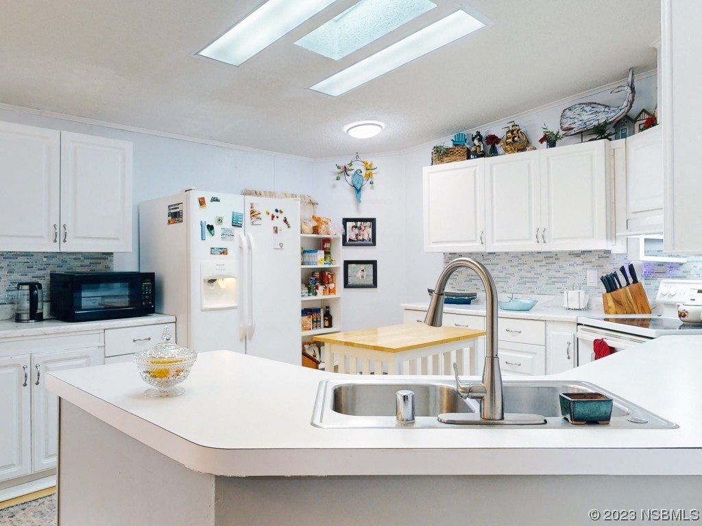 613 Portside Lane Edgewater, FL 32141 - Photo 18 of 49 a kitchen with a sink a stove and a refrigerator