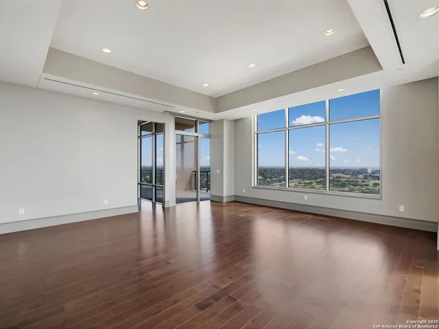 a view of empty room with wooden floor and fireplace