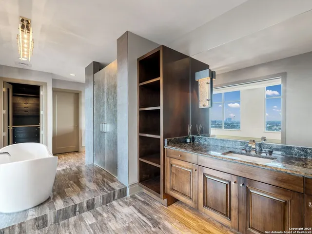 a spacious bathroom with a granite countertop sink and a mirror