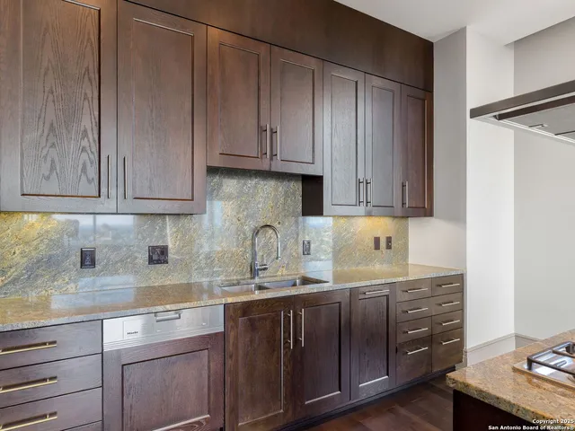 a kitchen with granite countertop wooden cabinets and a sink