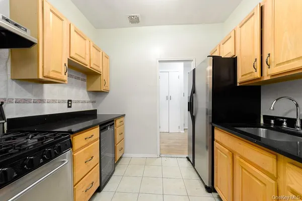 a kitchen with stainless steel appliances granite countertop a stove a sink and a refrigerator