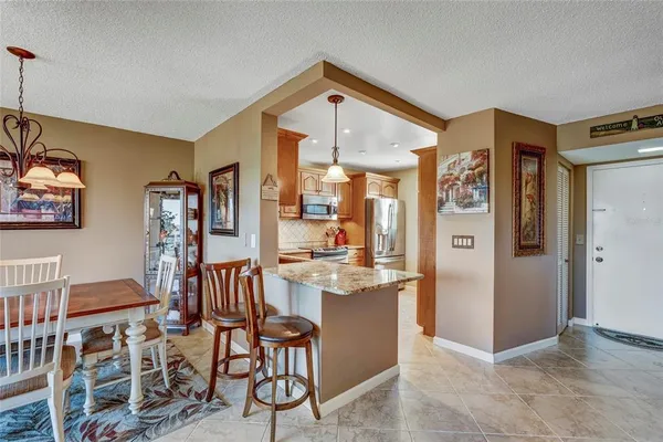 a open kitchen with stainless steel appliances granite countertop a refrigerator and a stove top oven