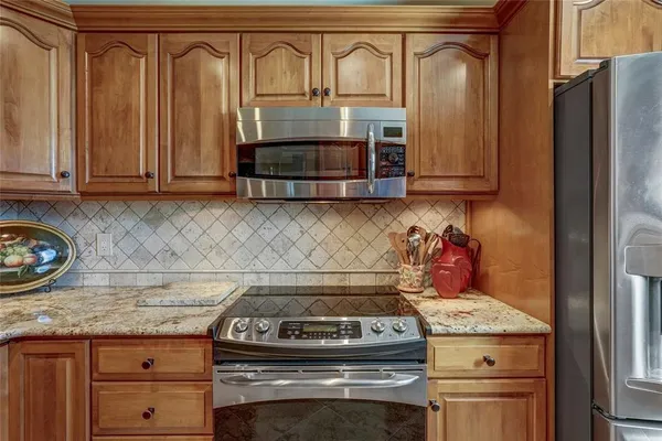 a kitchen with granite countertop a stove and a refrigerator