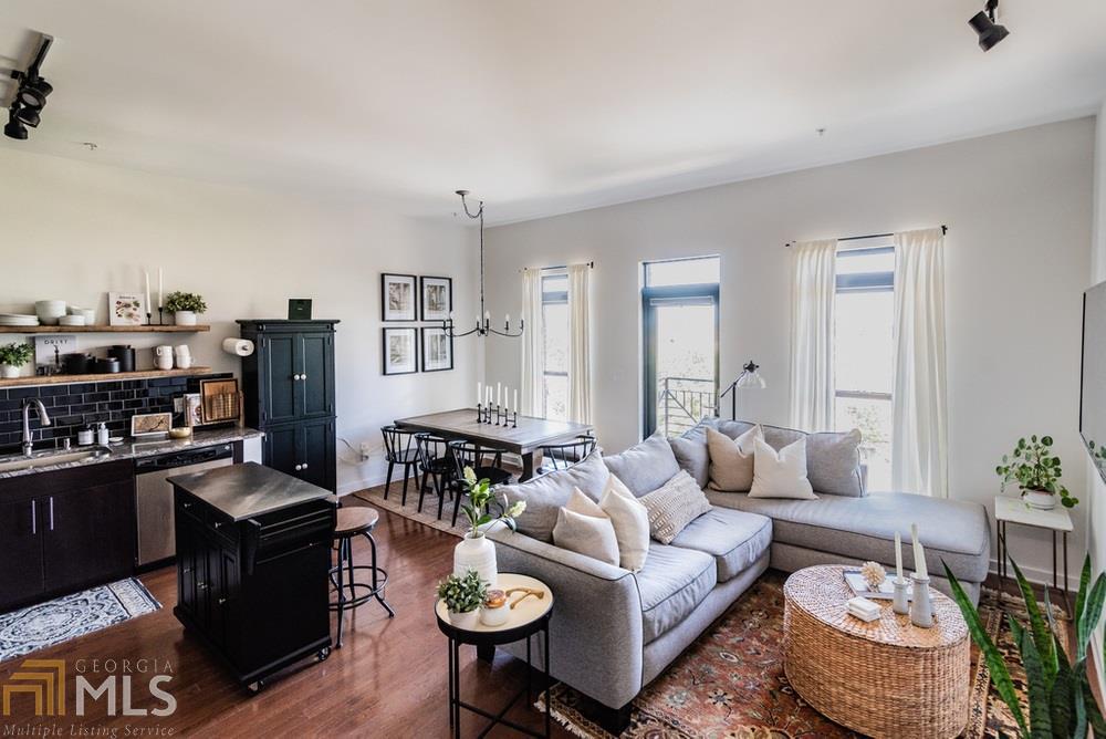 a living room with furniture and a dining table with wooden floor