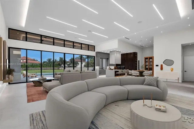 a view of an empty room with furniture and a large window