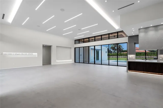 a view of an empty room with furniture and a large window