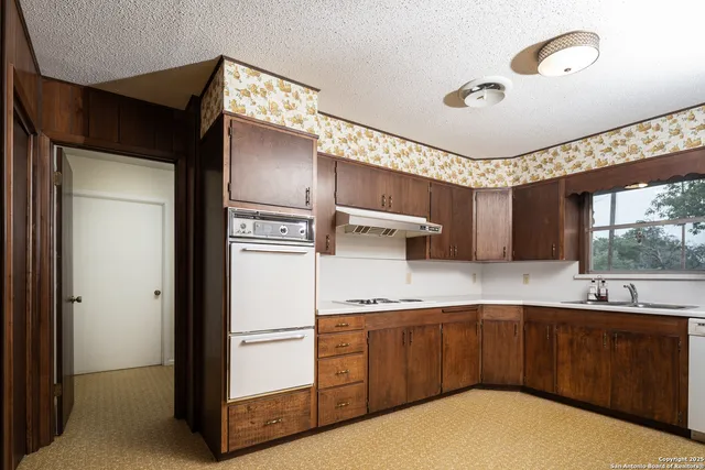 a kitchen with a refrigerator sink and cabinets