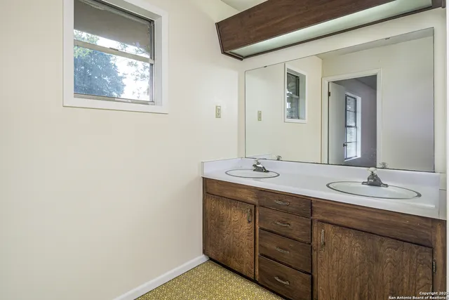 a bathroom with a double vanity sink and a mirror